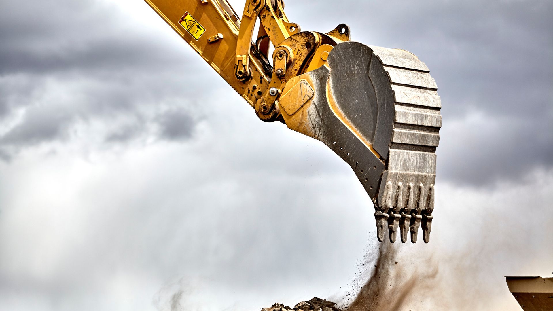 Excavadora en obra de construcción con implementos fabricados por METALSUR