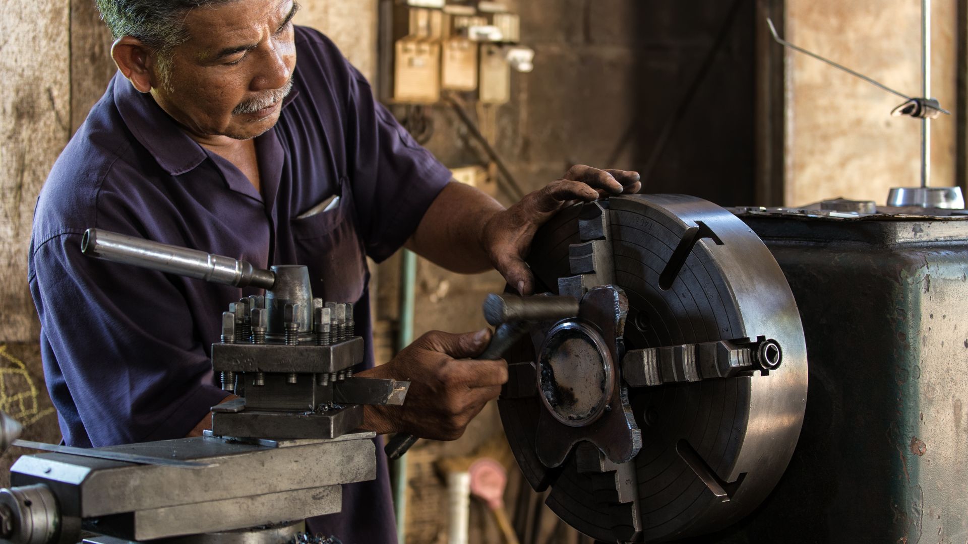 Operario mecanizando pieza en torno industrial — METALSUR Mecanizados Granada